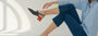 A woman seated on the floor wearing HUHUA navy slingbacks with sculpted red block heels